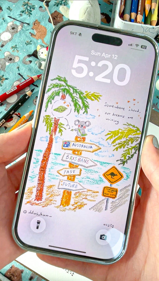 Phone with a travel-themed screen held by a hand, surrounded by stationery items.